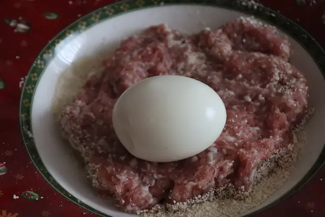 Storchennetz, gekochtes Ei wird mit Gehackten umhüllt und paniert, gebraten/frittiert, fertig, passt sehr gut zum Kartoffelbrei