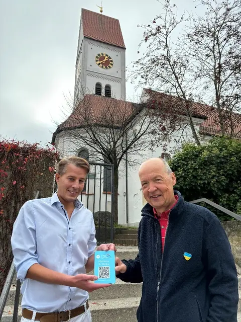 Die Köpfe hinter dem virtuellen Freilichtmuseum, Dr. Felix Petzold (links) und Thomas Werthefrongel mit der QR-Code-Tafel zur St.-Nikolaus-Kirche. | Foto: Stadt Stadtbergen