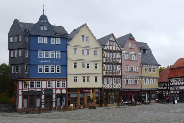 Die Nordzeile des Marktplatzes zeigt einen Neubau von fünf zusammenhängenden und einem Einzelgebäude nach historischen Fotografien und Bauplänen. Ausgewählt wurden die Gruppen Gießen, Marktplatz 21-23 sowie Gießen, Kirchenplatz 13 und 14. Die Fachwerkbauten hatten bis zu ihrer kriegsbedingten Zerstörung im Bereich des Gießener Marktplatzes gestanden. Es wurden nur die Fassaden rekonstruiert. Das Gebäude ist heute ein Hotel.