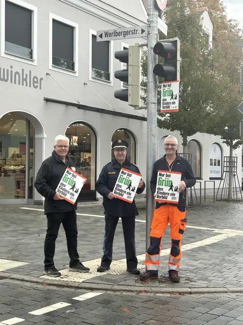 Mit der Aktion „Nur bei Grün – den Kindern ein Vorbild“ werben Helmut Beck (Kreisverkehrswacht), EPHK Michael Jakob (Polizei) und Josef Gail (Städtischer Bauhof, der die Schilder montierte), für ein Vorbildverhalten an den Ampeln.