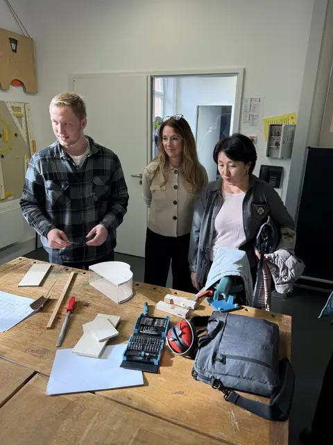Besuch am Staatsinstitut für die Ausbildung von Fachlehrern Augsburg - stellvertretende Institutsleiterin B. Siemer und E. Ishekeeva im Gespräch mit einem Studenten zu einem Unterrichtsprojekt im Fach Werken/Elektronik.