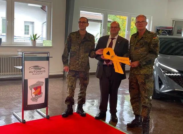 Oberst i.G. Dirk Bollinger (links) und Hauptmann Martin Würz (rechts) überreichen dem Geschäftsführer des Austohauses Masuch Herrn Peter Masuch die Gelbe Schlkeife des Förderverein Stab Division Schnelle Kräfte e.V. in Stadtallendorf | Foto: Martzin Würz / Evelyn Masuch