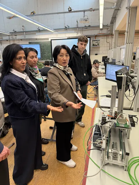 Besuch am BSZ Landsberg am Lech - S. Gupta, G. Usupova und E. Ishekeeva im Gespräch mit einem Schüler der Elektroniktechnikabteilung.