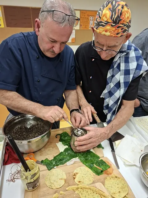 Nicht ganz so einfach die Pilzduexel gleichmäßig auf das Filet zu bringen und mit Spinat einschlagen. Aber Artur Silva links und Klaus Hill haben hier das richtige Händchen. | Foto: Otto Killensberger