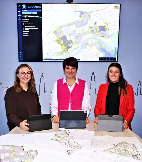 Auf dem Tisch Print-Ausdrucke, auf dem Bildschirm dahinter digitale Daten: Lauingen wird Pilotkommune für die DiPlanung, die digitale Bauleitplanung, im Landkreis Dillingen. Julia Stropek (links) und Alina Poll (rechts), beide von der Bauverwaltung der Stadt Lauingen, mit Lauingens 1. Bürgermeisterin Katja Müller. | Foto: Heike Siebert