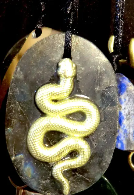 vergoldete Schlange auf grauem Labradorit