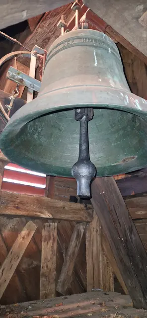 Blick von den letzten Leiterstufen in die Glockenstube auf die Glocke