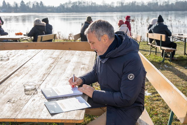 Neujahrs-Anbaden 2026 im Friedberger Baggersee. Friedbergs Erster Bürgermeister Roland Eichmann signiert Teilnehmer-Urkunden | Foto: FSeventfoto