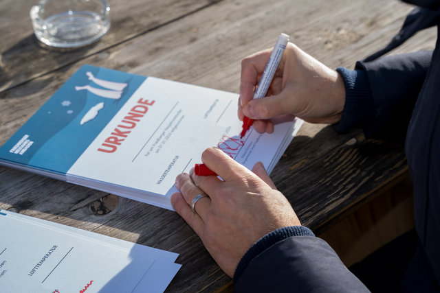 Neujahrs-Anbaden 2026 im Friedberger Baggersee. Friedbergs Erster Bürgermeister Roland Eichmann signiert Teilnehmer-Urkunden | Foto: FSeventfoto