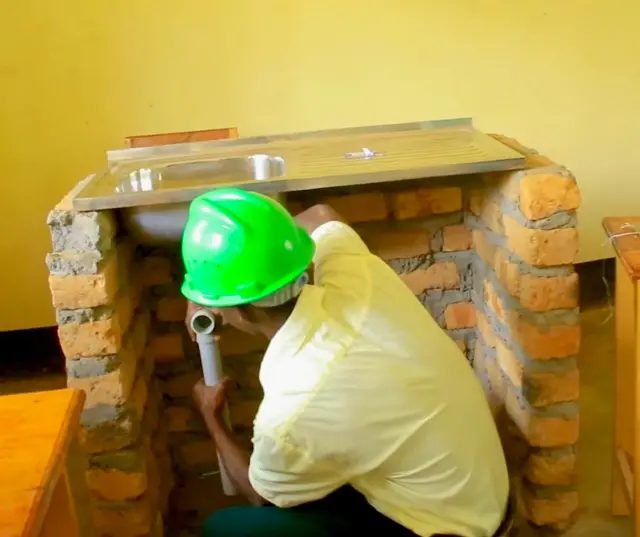 Schüler beim Anschließen eines Spülbeckens | Foto: Fr. Joseph Sserunjogi