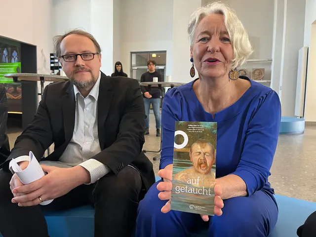 Museumsdirektorin Prof. Dr. Katja Lembke zeigt den Flyer für die kommende Ausstellung „Aufgetaucht“.