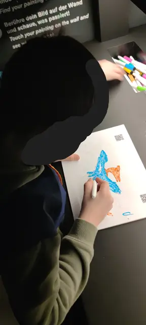 Die Welt der Dinosaurier im Port des Lumières. Im Kids`Atelier werden von den jüngsten Besuchern zuvor eigenhändig ausgemalte Dinosaurier auf eine große, farbenfrohe Filmleinwand projiziert.