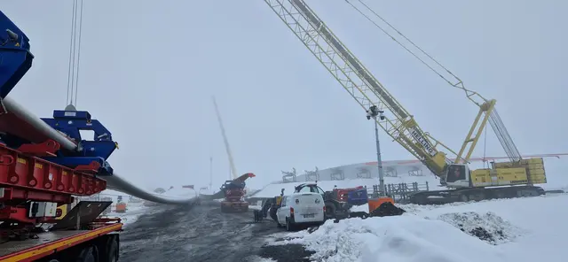 Angelieferten Rotorblätter mit einer Länge von 86 Metern werden vorsichtig auf vorbereitete Lagerplätze gehievt,