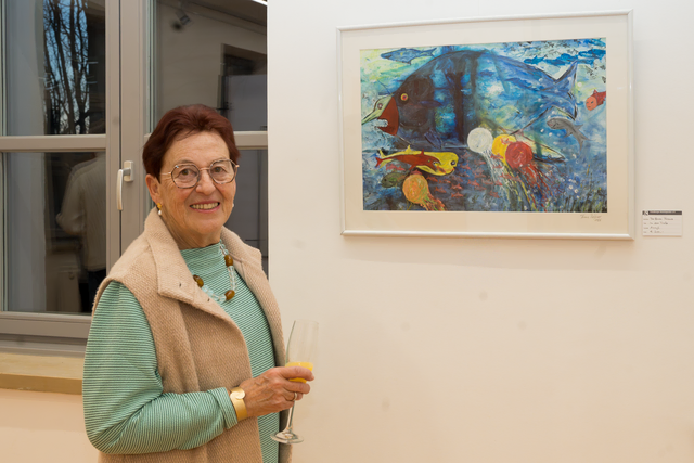 "In der Tiefe" - Ausstellung der Friedberger Kunstspechte e.V. in der Friedberger Archivgalerie. Martha Reißner vor dem Gemälde "In der Tiefe" von Franz Reißner. Martha Reißner hat leckere Snacks zu Finissage zubereitet.