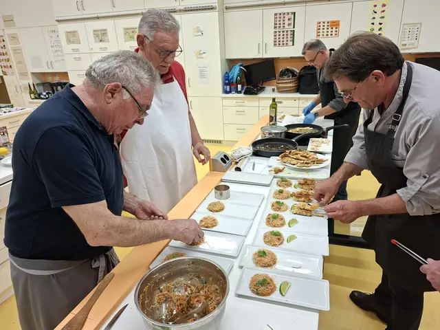 Anrichten - der Glasnudelsalat wartet auf die Fischstäbchen - dann gehts auf den Tisch. Vorne Links Karl Rupp, Willi Buhmeier sieht zu während Dr. Roland Ziegler die Fischstäbchen auflegt. | Foto: Otto Killensberger