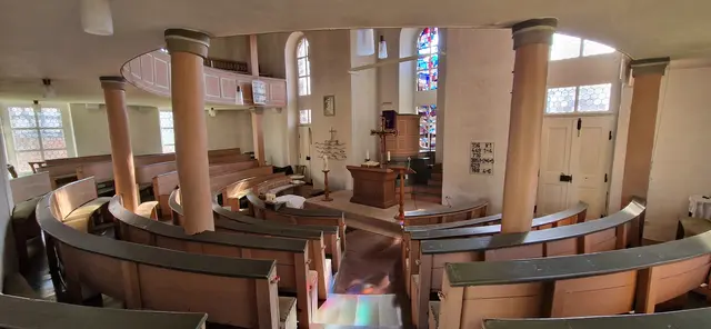 Kirche Wollmar- Besonderheit: Im Inneren verfügt sie über eine seltene amphitheatrische Anordnung des Gestühls, was eine einzigartige Raumakustik und Atmosphäre schafft.