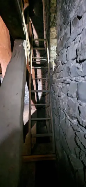 durch die Glockenturmmauer über eine Leiter nach unten