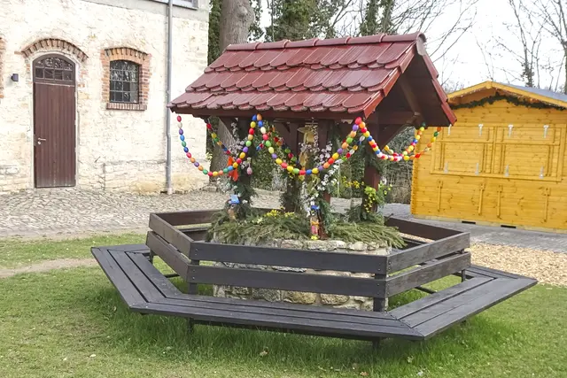 der österlich geschmückte Brunnen auf dem alten Gutshof
