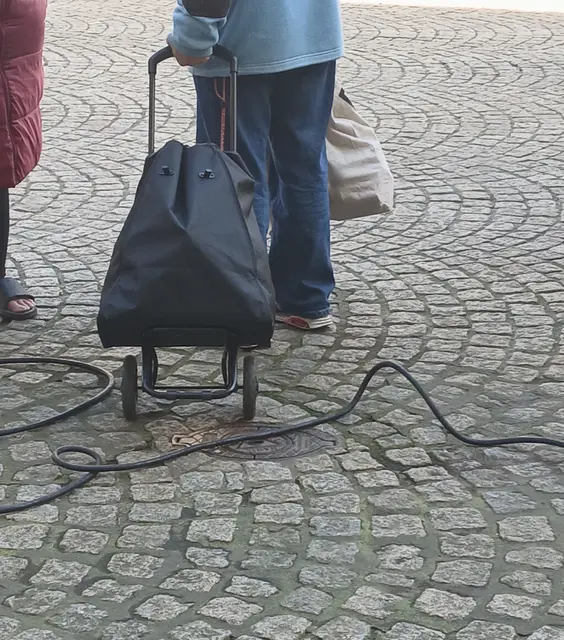 Lose über den Boden in Schlaufen, teilweise in hochgestellten Schlaufen verlegte Stromkabel (schwarze Gummischlauchleitung) auf dem Marktplatz "Großer Markt" in Wesel.
Sachstand: Mittwochsmarkt 1. April 2026 | Foto: Siegmund Walter, 01.04.2026, 10:38 Uhr
