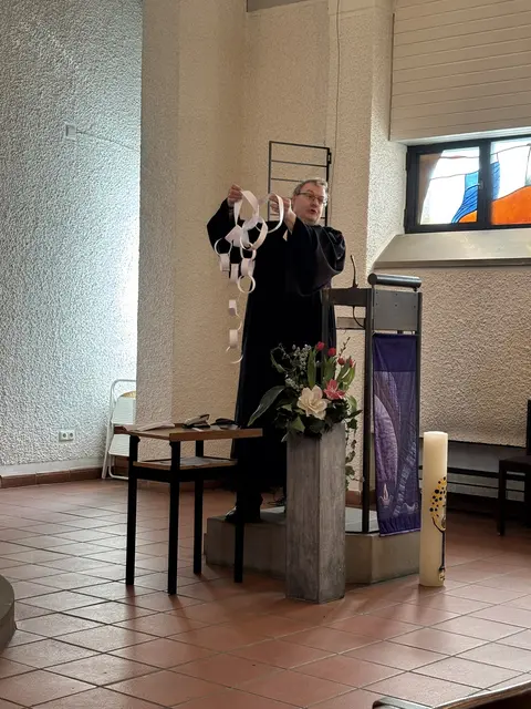 Im ökumenischen Gottesdienst verdeutlichte Pfarrer Dr. Falko von Saldern die Liebe Gottes - und fertigt eine Liebeskette an, zu der viele ihren Beitrag leisten