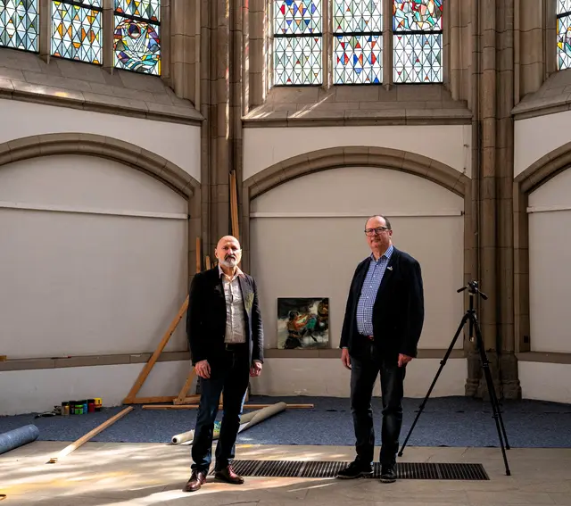 Das Foto zeigt Maler Walter Maria Padao (links) und Pfarrer Martin Winterberg in der Salvatorkirche beim Aufbau des Offenen Ateliers.
Foto: Rolf Schotsch
