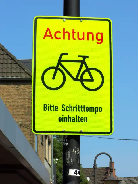Signalfarbiges Hinweisschild für Radfahrende in Fußgängerzone. | Foto: Siegmund Walter, 31.08.2024, 13:00 Uhr