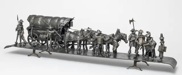 Jakob Fugger, dargestellt mit der Schriftrolle im Fuggerzug und einem Schreiber (rechts). Schmiedearbeit von Erich Nüchter.