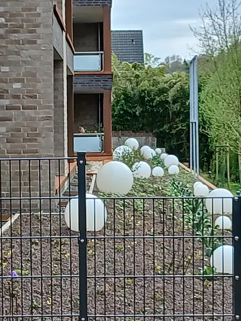 Eine Vielzahl weiße Gartenkugellampen in unterschiedlichen Größen, in Grünanlage (Garten) eines Mehrfamilienhauses. | Foto: Siegmund Walter, 11.04.2026, 15:43 Uhr