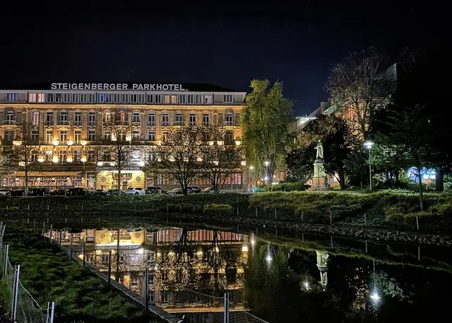 Das Parkhotel (1902 eröffnet) spiegelt sich im Kö-Bogengraben. Rechts im Hofgarten das Cornelius-Denkmal von Adolf von Donndorf (1879). Peter von Cornelius war der erste Direktor der 1819 neu gegründeten Königlich-Preußischen Kunstakademie in Düsseldorf. | Foto: copyright Margot Klütsch