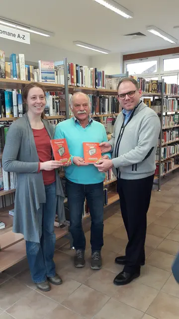 Buchübergabe in der Bücherei Wennigsen 2015 Winni mit Bürgermeister Meinecke und der Büchereileiterin - im Buch die Eltengeschichte | Foto: Winfried Gehrke