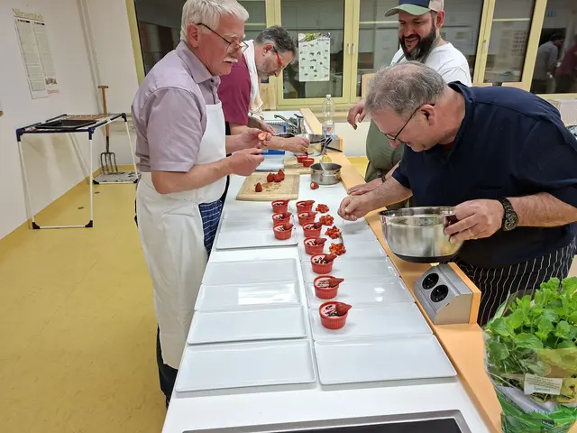 Auf geht´s zum Endspurt: der Nachtisch wird angerichtet. Die Erdbeer-Pannacotta von Georg Lipp wird mit einem Balsamico-Sirup und einer halben Erdbeere verziert. Artur Silva richtet die marinierten Erdbeeren an während Dr. Alois Moosmiller hinten den Balsamico-Sirup aufbringt. | Foto: Otto Killensberger