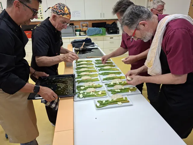 Vorne rechts: Dr. Alois Moosmiller zerbröselt den Büffelmozarella. Links vorne Claudio Erdner und daneben Klaus Hill der das Öl mit einem Kaffeelöffel darüber träufelt..