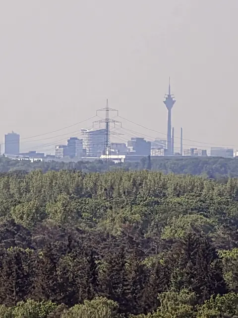 Der Rheinturm in Düsseldorf, ein markantes Wahrzeichen mit einer Höhe von 240,5 Metern.Im Hintergrund sind weitere Teile der Düsseldorfer Skyline sowie moderne Gebäude im Medienhafen zu sehen.