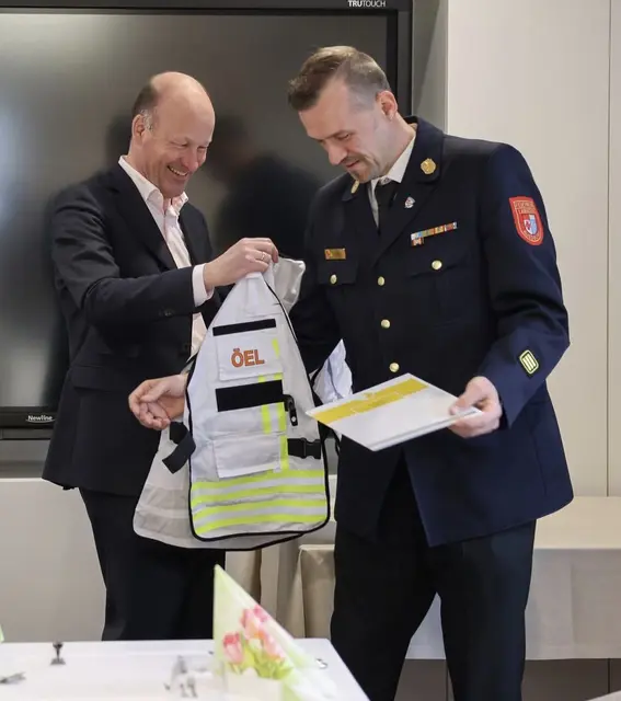 Landrat Martin Sailer übergibt dem neu ernannten Örtlichen Einsatzleiter, Tom Mair seine Einsatzweste | Foto: Julia Pietsch; LRA Augsburg