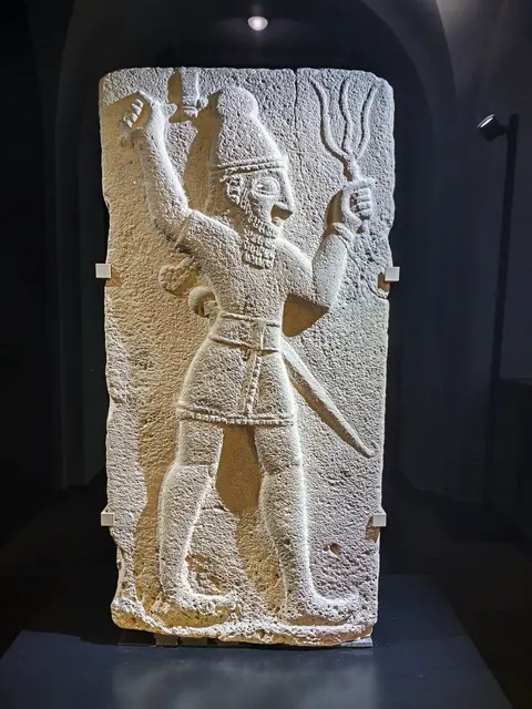 Wettergott mit gebündelten Blitzen und einer Axt, Basalt, etwa 850 v. Chr. aus dem heutigen Zincirli, Türkei
angebracht war dieses Relief am äußeren Burgtor der hethitischen Stadt Sam`al