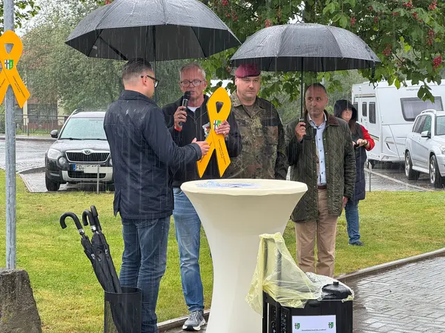 Gut "beschirmt" übernahm Bürgermeister Hohnstein (li.) von Martin Würz (2.v.links)  die Gelbe Schleife in Anwesenheit von Oberst d.R. Seifert und Hauptmann d.R Dr. Marcello Camerin als 2. Vorsitzender des Fördervereins Stab DSK | Foto: Martin Würz