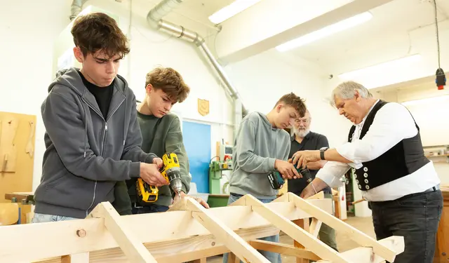 Schüler des Kemptener Allgäu-Gymnasiums bei Arbeiten an einem Dachstuhl-Modell im BTZ Kempten unter Anleitung von Lehrmeister Günter Bayer.  | Foto: Sascha Schneider, HWK Schwaben