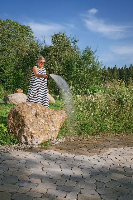 Durchlässige Pflastersteine lassen Wasser direkt in den Boden versickern. So geht beim Gießen nichts verloren. | Foto: DJD/braun-steine/Benedikt Walther