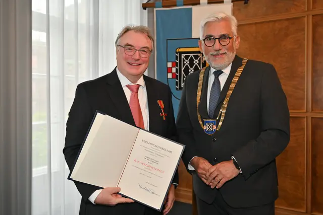 Ralf Erdmann (links) wurde mit dem Bundesverdienstkreuz ausgezeichnet, das ihm Bochums Oberbürgermeister Jörg Lukat (rechts) im Rahmen einer Feierstunde im Rathaus überreichte.  | Foto: Stadt Bochum