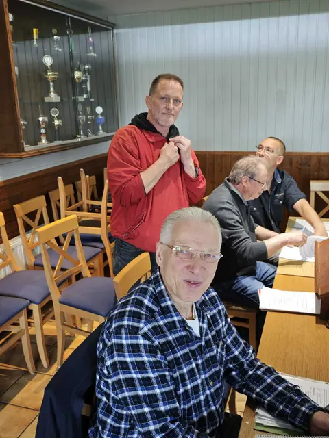 Vier Vorstandsmitglieder des KGV Dornröschen stehen bzw. sitzen in einem Raum: von links Andreas Schmitt als 1. Schriftführer, daneben Markus Schmidt als 2. Vorsitzender, gefolgt von Eugenio Maiolo, der zum Zeitpunkt der Aufnahme 2. Kassierer war und am Ende der Neuwahlen zum 1. Vorsitzenden gewählt wurde. Rechts im Hintergrund steht Manuel Diefert, der während der Versammlung noch 2. Kassierer war und am Ende der Neuwahlen zum 1. Kassierer gewählt wurde.