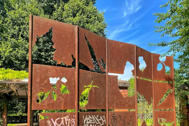 Mitten im Garten steht der Paravent aus inzwischen angerosteten Blechtafeln mit ausgestanzten pflanzlichen Motiven. Durch sie betrachtet man die Natur als Lichtbilder (Christian Bauer, 1996).  | Foto: copyright Margot Klütsch