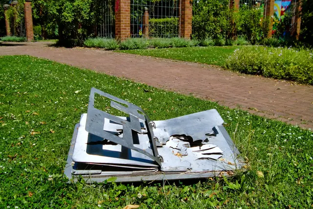 Mitten auf der Wiese gibt das Umklappbuch aus Edelstahl „Ausblicke“ frei, die die Kinder vorher im Garten auf Karton gezeichnet haben (Stefanie Oelke, 1997). | Foto: copyright Margot Klütsch
