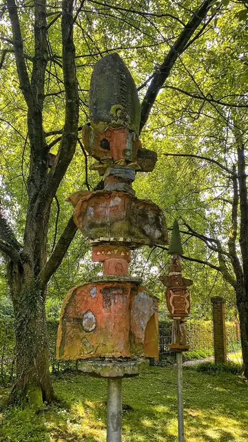 Im Schatten der Bäume verstecken sich drei Totempfähle aus Stahlrohr mit geheimnisvollen Figuren aus Keramik (Elke Richter, 1995).  | Foto: copyright Margot Klütsch