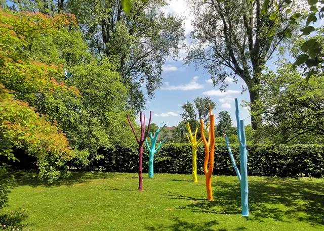 Zwischen natürlichen Bäumen stehen fünf Kunstbäume aus bemalten Baumstämmen zum Spielen (Tanja Gemmer, 2014).  | Foto: copyright Margot Klütsch