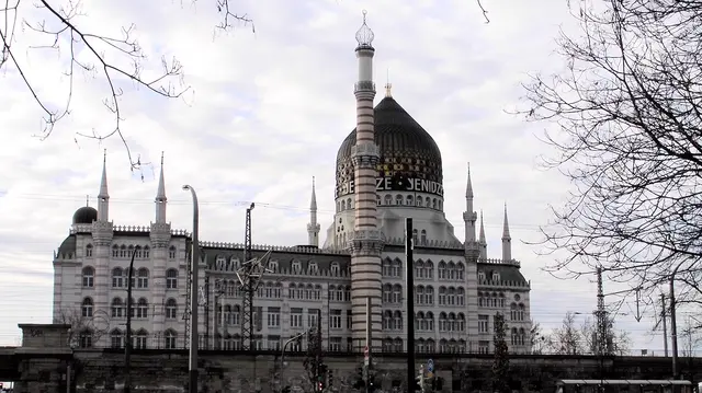 Die „Tabakfabrik Dresden“ meint in der Regel die Yenidze, eine der ungewöhnlichsten Industriearchitekturen Deutschlands. Sie war ursprünglich eine Zigarettenfabrik, wurde aber im Stil einer orientalischen Moschee gebaut – mit Kuppel, Minarett‑ähnlichem Schornstein und farbigen Glasfenstern. Heute ist sie ein Bürohaus mit Restaurant und Theater in der Kuppel.