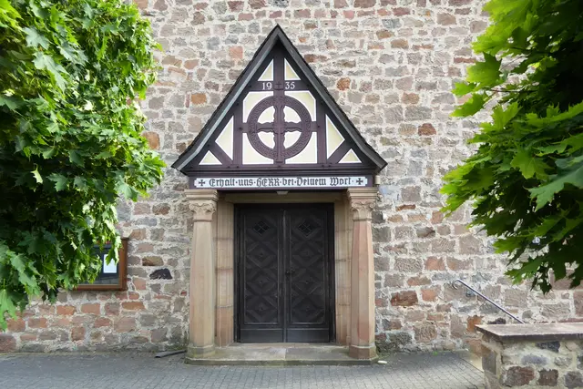 Erstellt wurde die Kirche nach Plänen des Marburger Architekt Dr. Karl Rumpf. Zwei Säulen tragen ein kleines Vordach („Porticus“) über dem Eingang. 