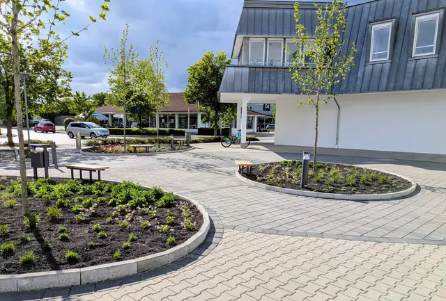 Der neue Quartiersplatz im Stadtberger Markt: wo sich bislang die Zufahrt zum Parkdeck befand, stehen nun Sitzbänke und ein Trinkwasserbrunnen. | Foto: Martin Bruckmeier, Stadt Stadtbergen