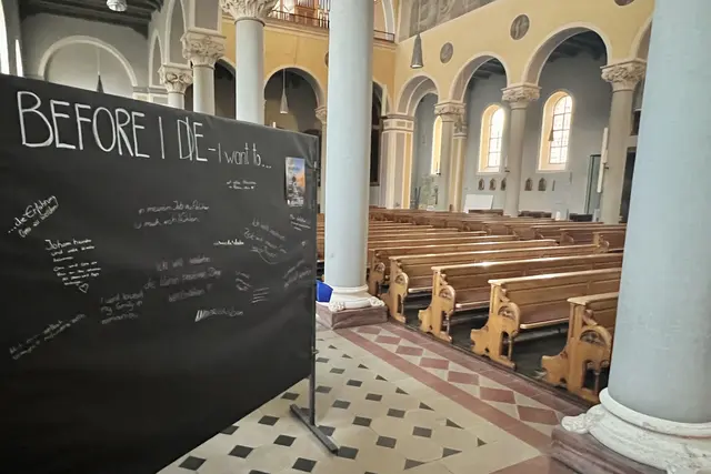 Das interaktive Kunstprojekt „Before I die …“ der US-Künstlerin Candy Chang lädt Menschen dazu ein, den Satz „Bevor ich sterbe, möchte ich …“ zu vollenden. In der Stadtpfarrkirche St. Jakob stand eine von weltweit über 5.000 Tafeln, an denen jeder Wünsche, Hoffnungen und Lebensziele sichtbar machen konnten. Die Tafel regt dazu an, sich mit der eigenen Vergänglichkeit und den wirklich wichtigen Dingen des Lebens auseinanderzusetzen. | Foto: P. Steffen Brühl