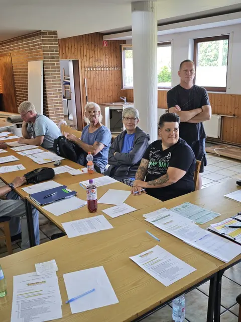 Fünf Mitglieder des KGV Dornröschen sitzen und stehen an einem großen Tisch im Vereinsheim: vorne rechts Mareike Kallweit, dahinter Markus Schmidt, links daneben Yvonne Kraft, daneben Reinhard Thomas und ganz rechts Thorsten Mehtke.