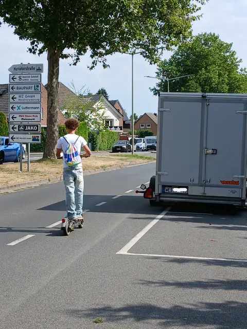 Junger E-Scooter-Fahrer im Schutzstreifenbereich der Brüner Landstraße in Wesel.
Rechts im Bild, längsparkender Anhänger, der etwa ein Drittel des Schutzbereiches einnimmt und somit Radfahrende gefährdet.
Sachstand: seit geraumer Zeit! | Foto: Siegmund Walter, 17.07.2026, 10:38 Uhr